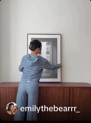 Creator styling artwork above a wooden HERNEST media console.