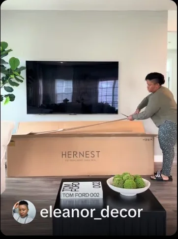 Creator opening a HERNEST furniture carton in a living room.